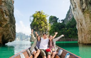 Happy family boat trip on summer vacation in Ratchaprapha Dam, Khao Sok National Park, Surat Thani Province, Thailand ( Guilin of Thailand )