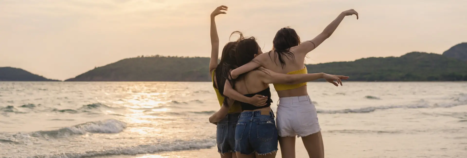 three-friends-enjoying-beach-having-fun-sunset