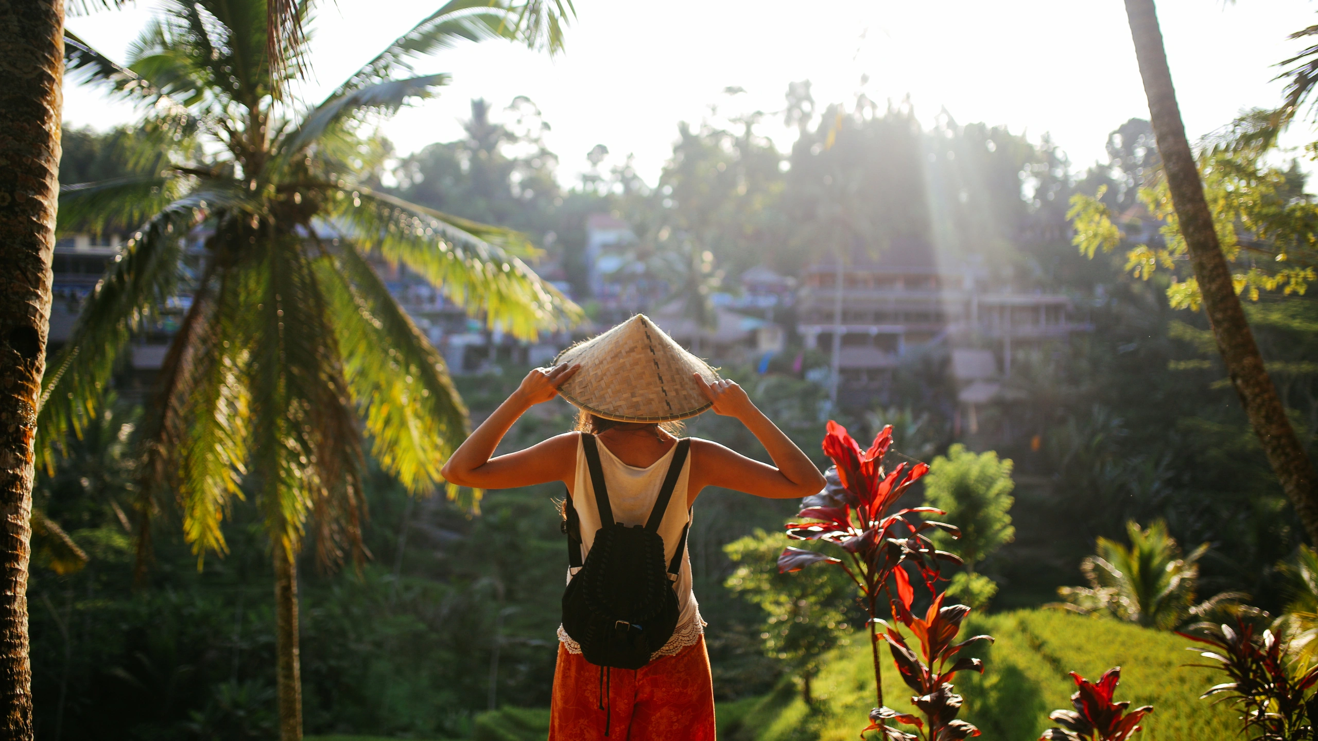 A woman strolls past a temple in Ubud, where good food is always around the corner.