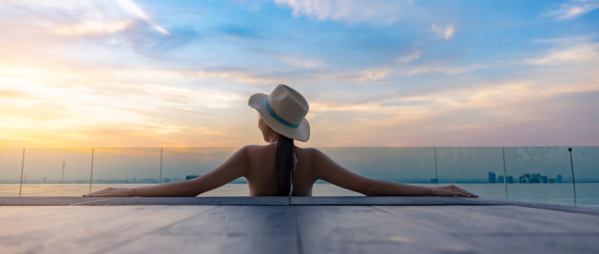 woman-wearing-hat-enjoying-pool-sunset